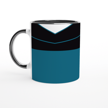 A white mug displays a design inspired by a Star Trek TNG uniform featuring black, teal, and silver panels.