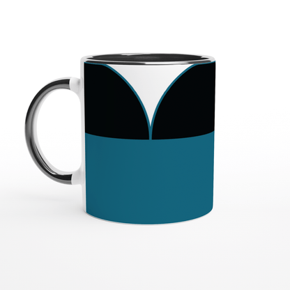 A white ceramic mug displays a design inspired by Star Trek: The Next Generation uniforms, featuring blue, black, and white geometric shapes.