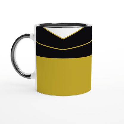 A white ceramic mug displays a design inspired by a Star Trek TNG uniform featuring black, gold, and gray panels.