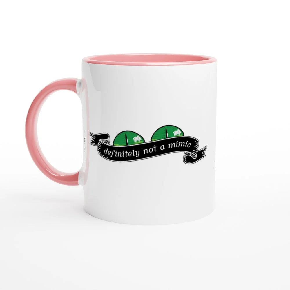 A white mug with a pink handle and interior features a cartoonish D&D mimic illustration and the words "definitely not a mimic" on a banner.