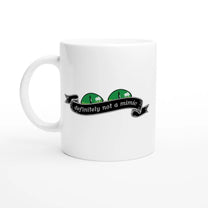 A white mug displays a green D&D mimic face peeking out from behind a banner that reads "definitely not a mimic.