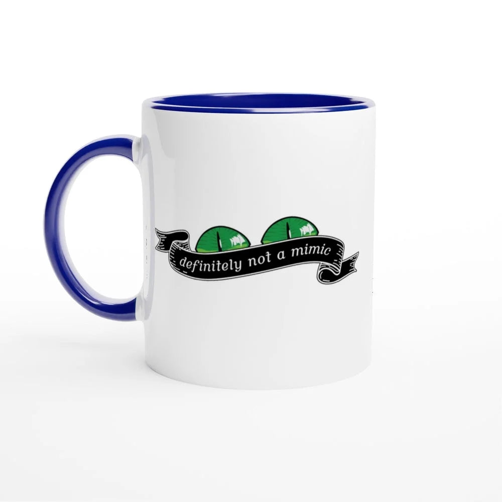 A white mug with a blue handle and rim features a cartoonish green mimic monster design and the words "definitely not a mimic" in a banner.
