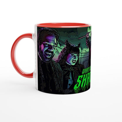 A red mug displays an illustration of Laszlo and Nadja from What We Do In The Shadows, along with a partial view of another figure and text on the side.