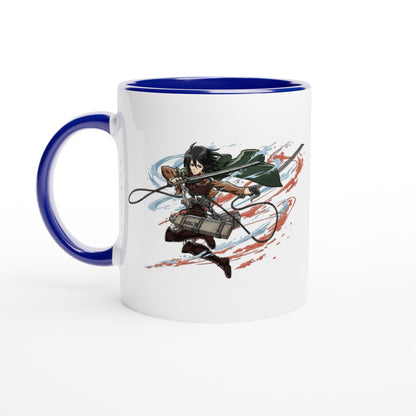 A white ceramic mug features an illustration of Mikasa Ackerman from the Attack on Titan anime series wielding her blades against a red and blue background.