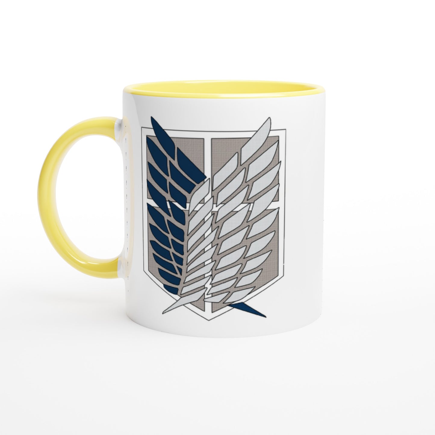 A white ceramic mug with a yellow handle and rim displays the Wings of Freedom emblem from Attack on Titan.