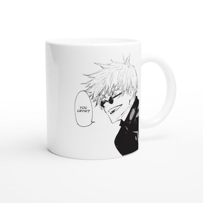 A white ceramic mug displays a black and white manga panel of Satoru Gojo from Jujutsu Kaisen wearing sunglasses and speech bubble reading "You Cryin'?".