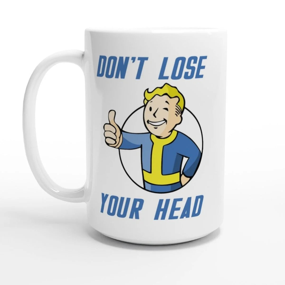 A white mug displays a Vault-Tec mascot giving a thumbs up with the phrase "Don't Lose Your Head" printed above and below.