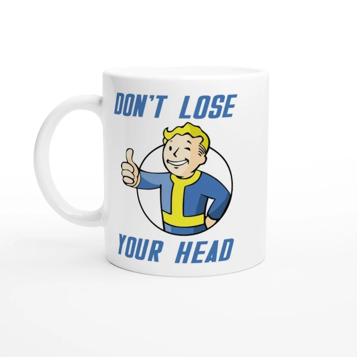 A white mug displays a Vault-Tec mascot giving a thumbs up above the text "Don't Lose Your Head" referencing the Fallout video game series.