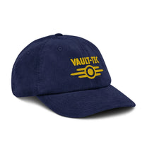 A blue Vault-Tec baseball cap features yellow embroidered lettering and a logo referencing the Fallout video game series.