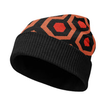 A knitted winter beanie featuring a black, orange, and red geometric pattern inspired by The Shining Overlook Hotel carpet.