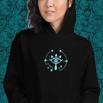 A person wears a black Zelda Sheikah Eye embroidery hoodie featuring a glow-in-the-dark design inspired by The Legend of Zelda: Tears of the Kingdom and Breath of the Wild.