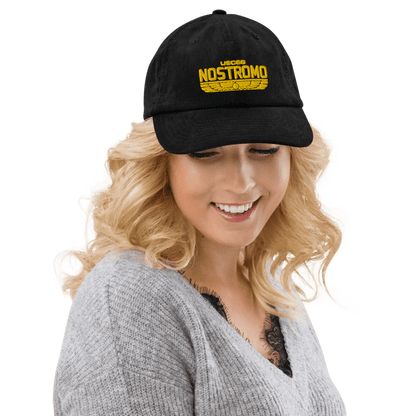 A person wearing a black Alien USCSS Nostromo embroidered hat with a Wings Style logo on the front.