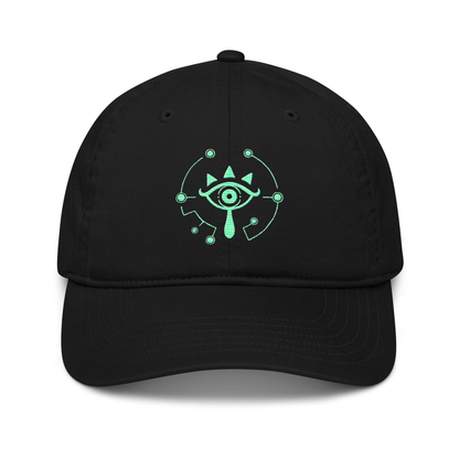 A black dad hat features a glowing green Sheikah eye emblem embroidered on the front, referencing the Tears of the Kingdom video game.
