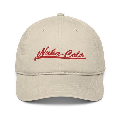 A beige Nuka Cola embroidered dad hat features red script lettering on the front panel.