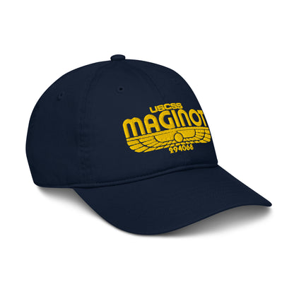 A navy blue baseball cap features an embroidered logo of "USCSS Maginot" along with wing-like designs and a number on the front panel.