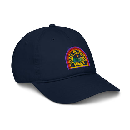 A navy blue baseball cap features an embroidered logo depicting the USCSS Maginot from the Alien franchise in a rainbow style design.