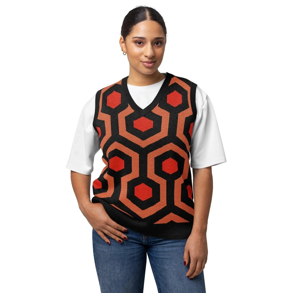 A person wearing a V-neck knitted sweater vest featuring the orange, black, and brown Overlook Hotel carpet pattern.