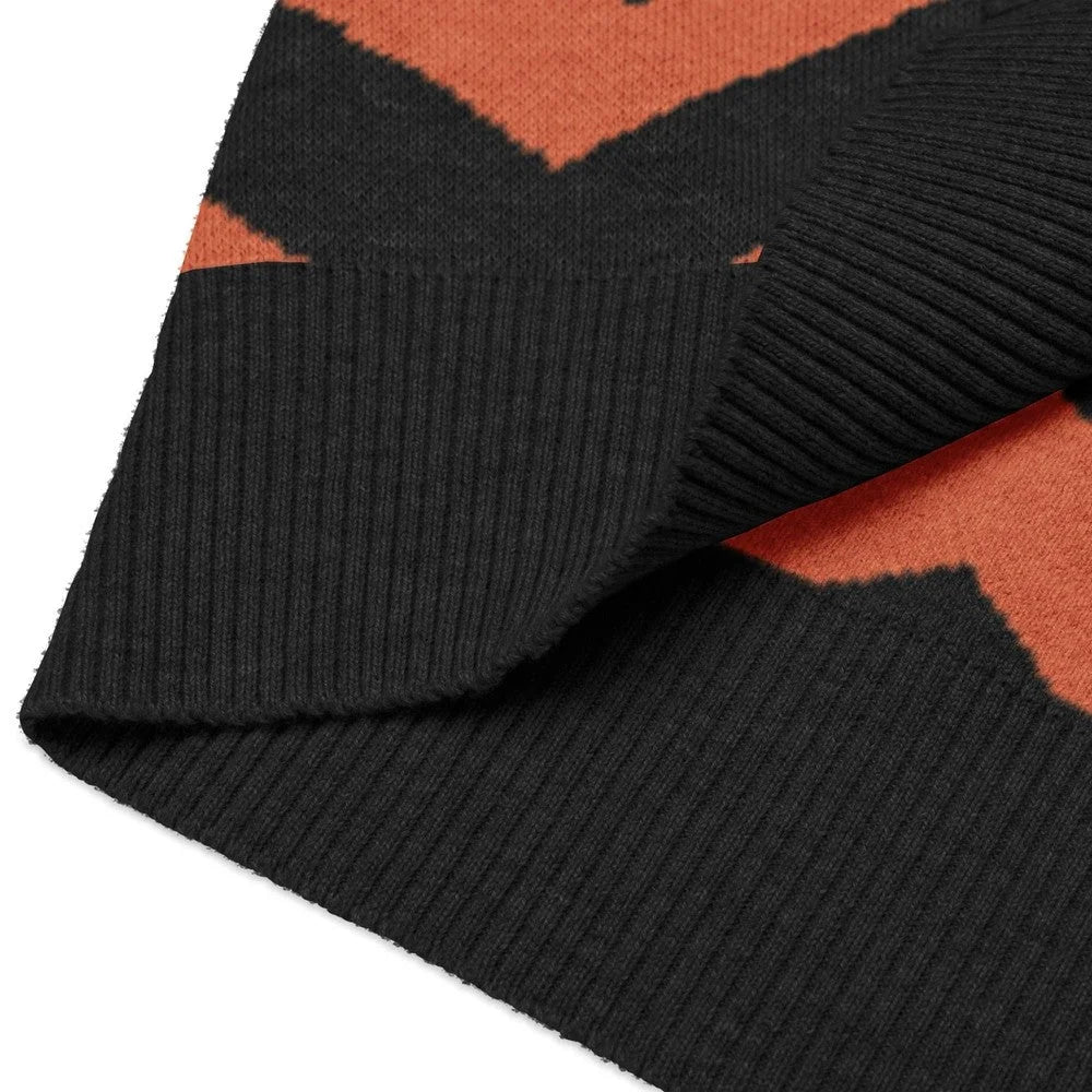 Close-up view of the black and orange Overlook Hotel carpet pattern on a knitted sweater vest.