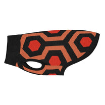 A knit pet sweater featuring a geometric orange, red, and black pattern inspired by the Overlook Hotel carpet.