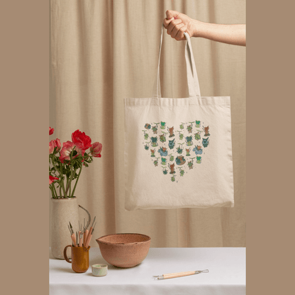 The Quirkify Korok Heart Pattern Shopping Tote Canvas Bag, features a gaming design with a heart-shaped motif of Koroks from TOTK / BOTW. It adds Zelda-inspired charm to any setting.