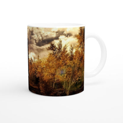 A white ceramic mug displays a landscape scene from Skyrim, featuring golden trees under a cloudy sky and a glowing blue symbol in the center.