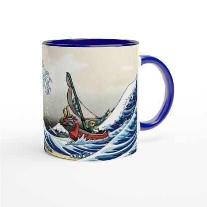 A white mug with a blue rim and handle depicts Link from Legend of Zelda Wind Waker sailing through a stylized wave inspired by The Great Wave off Kanagawa.