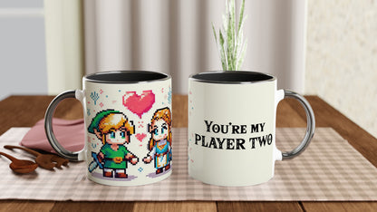 A white mug featuring chibi pixel art of Link and Zelda from The Legend of Zelda, along with the text "You're My Player Two.