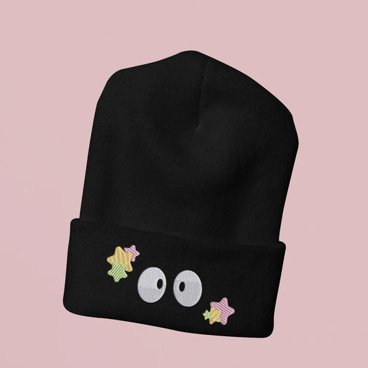A black Soot Sprites beanie features embroidered stars and three large eyes inspired by Ghibli's Susuwatari.