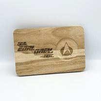 A wooden chopping board features laser-engraved text reading "Tea, Earl Grey, Hot" and a Star Trek delta shield symbol.