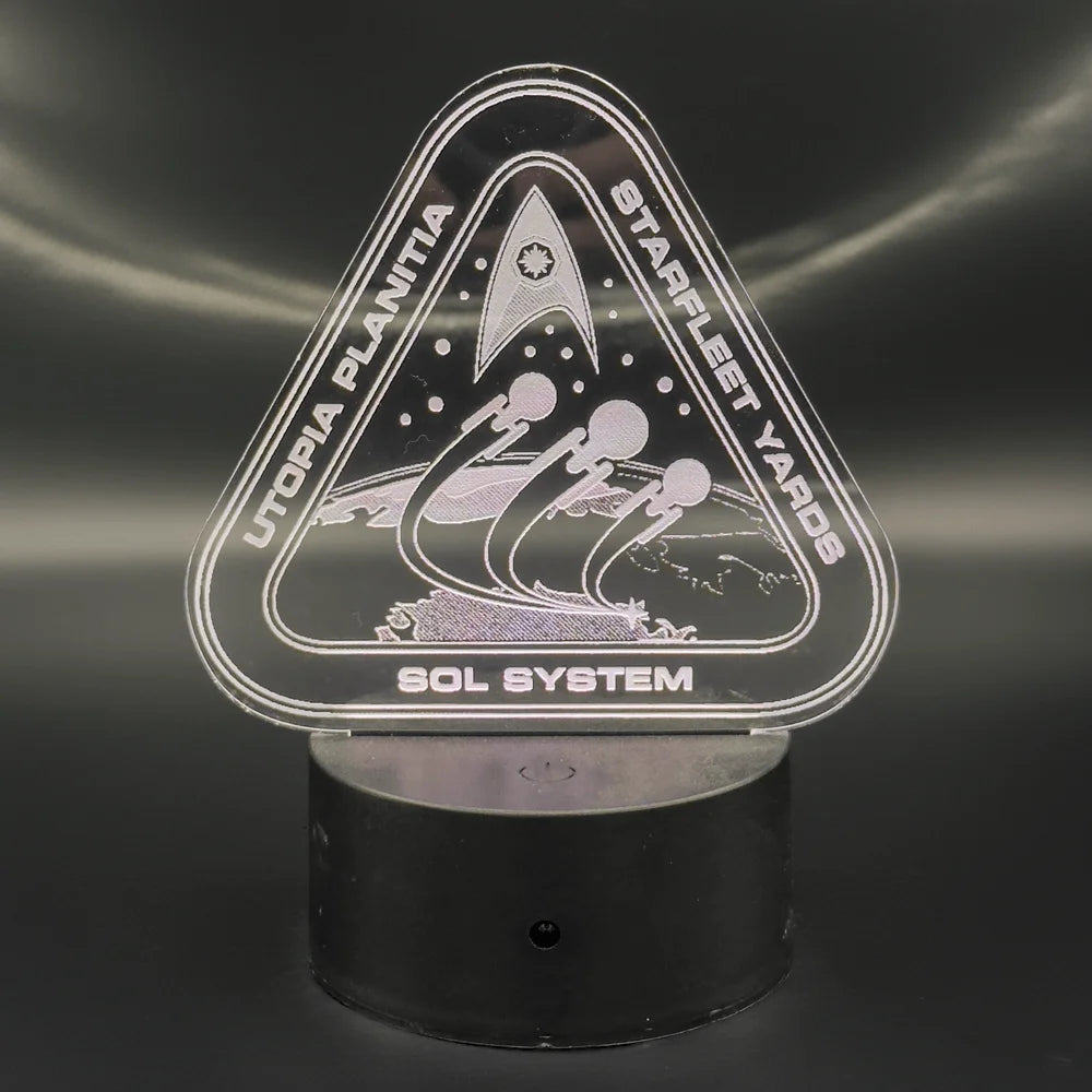An LED engraved acrylic lamp depicts a Starfleet Yards logo for Utopia Planitia and the Sol System, featuring spacecraft silhouettes.