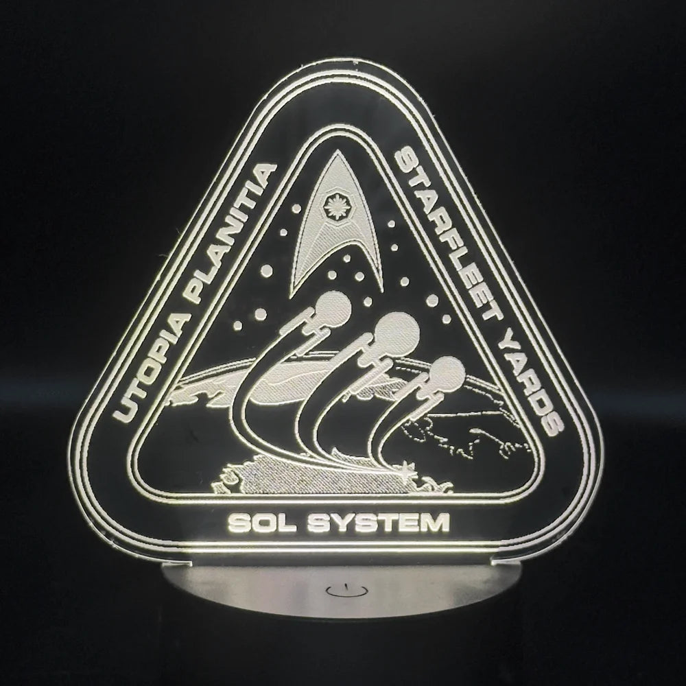 The illuminated acrylic lamp features an engraved design depicting Starfleet Yards at Utopia Planitia and the Sol System from the Star Trek universe.