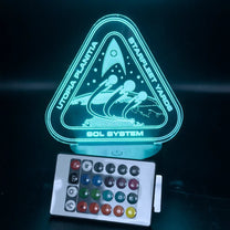 An LED engraved acrylic lamp depicts a Starfleet shipyard scene from Utopia Planitia, labeled "Starfleet Yards" and "Sol System," illuminated in blue light and controlled by a remote.