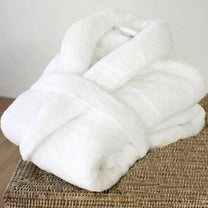 A fluffy white Stardew Valley cosy robe is folded neatly on a woven chair.