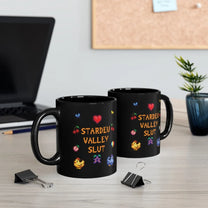 Two black mugs featuring pixel art graphics and the text Stardew Valley Slut sit on a desk next to a laptop and binder clips.