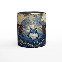 A cylindrical mug displays a Studio Ghibli Totoro character sitting within a blue and gold chinoiserie-style cherry blossom forest scene.