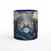 A ceramic mug depicts Totoro from Studio Ghibli sitting amongst a blue and white cherry blossom forest in a chinoiserie style.
