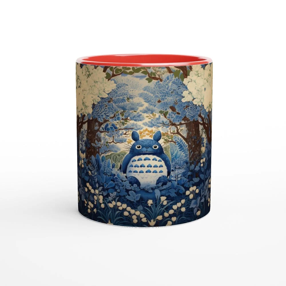 A ceramic mug depicts Totoro from Studio Ghibli sitting within a blue and gold chinoiserie-style cherry blossom forest scene.