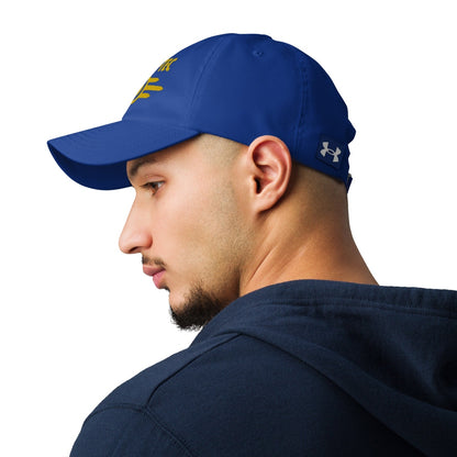 A man wears a blue Vault-Tec baseball cap featuring yellow embroidered lettering, as seen in the Fallout video game series.