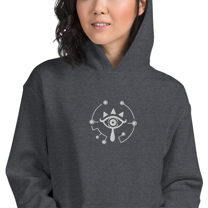 A person wearing a gray hoodie featuring an embroidered Sheikah Eye design inspired by The Legend of Zelda video game series.