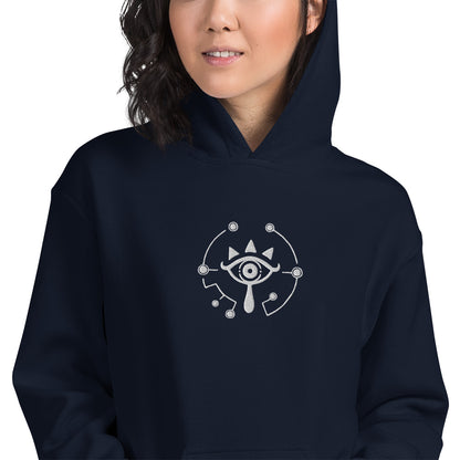 A person wearing a dark blue hoodie featuring embroidered Sheikah Eye artwork referencing The Legend of Zelda: Breath of the Wild and Tears of the Kingdom.