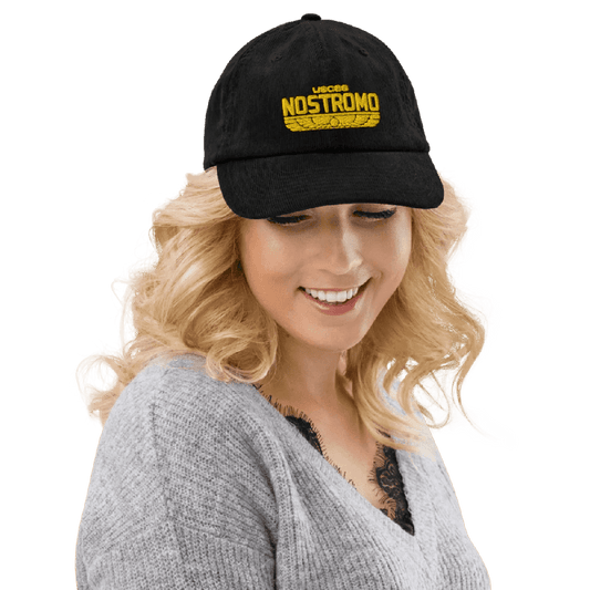 A person wearing a black Alien USCSS Nostromo embroidered hat with a Wings Style logo on the front.
