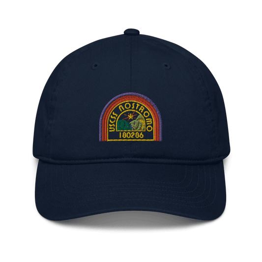 A navy blue baseball cap features an embroidered logo of the USCSS Nostromo with a rainbow style design and the number 180286.