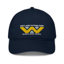 A navy blue baseball cap features an embroidered Weyland-Yutani Corp logo and the words "Building Better Worlds".