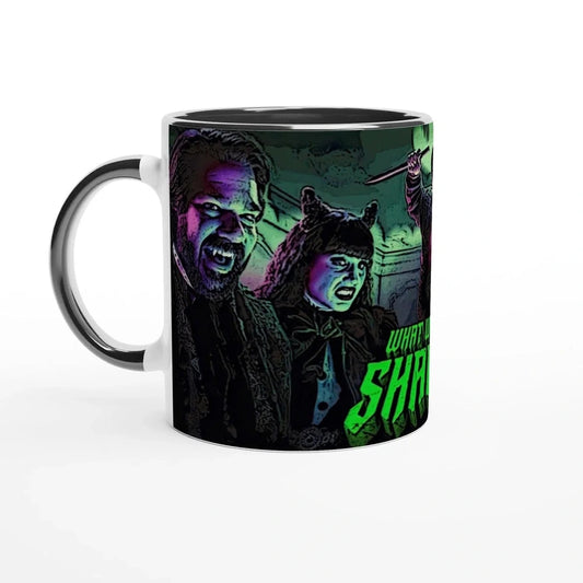 A ceramic mug displays a stylized illustration of Laszlo and Nadja from What We Do In The Shadows, along with partial text on the bottom.